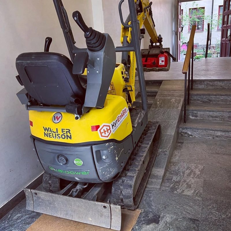 Mini-grävaren där andra inte tar sig in — upp för trapporna,